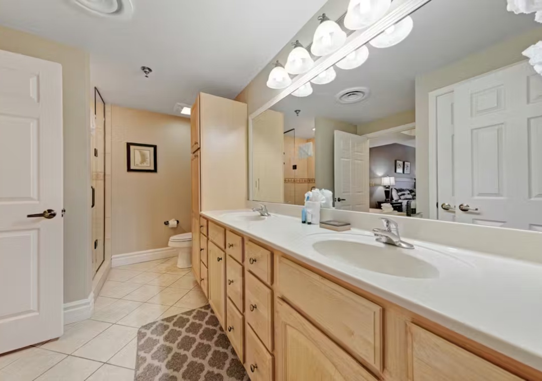Freshen up in your spacious master bathroom featuring dual sinks, ample storage, and warm lighting for your morning routine.