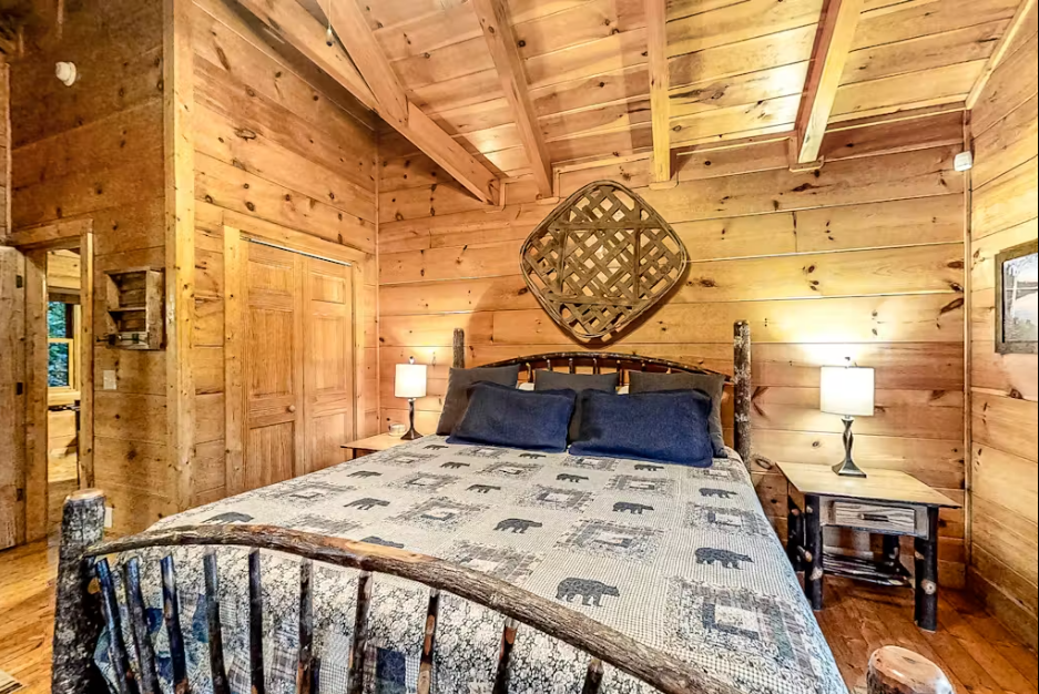 Drift off to sleep surrounded by warm pine walls and rustic charm in your cozy cabin bedroom.