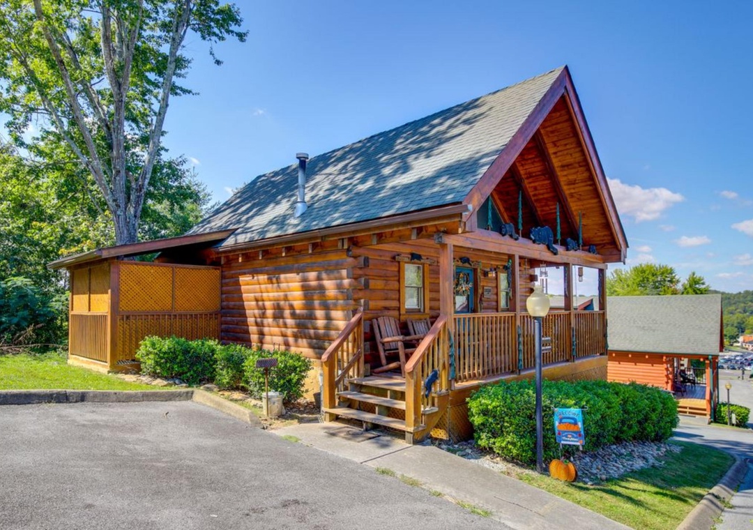 Charming log cabin with mountain architecture and mature trees creating a peaceful woodland setting.