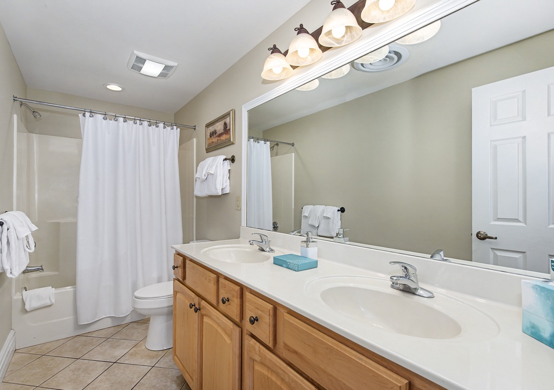Your spacious bathroom features dual sinks and warm wood vanity, perfect for getting ready together in comfort.