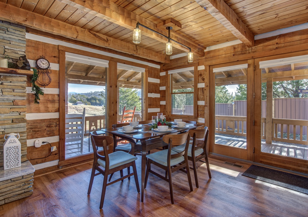 Gather around your rustic dining table where warm wood beams and panoramic windows create the perfect setting for memorable meals together.