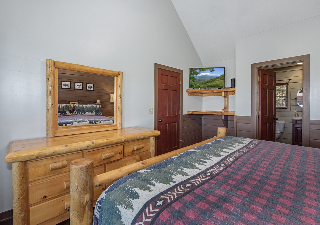 Cozy mountain lodge bedroom features rustic log furniture and wildlife-themed bedding for your peaceful retreat.