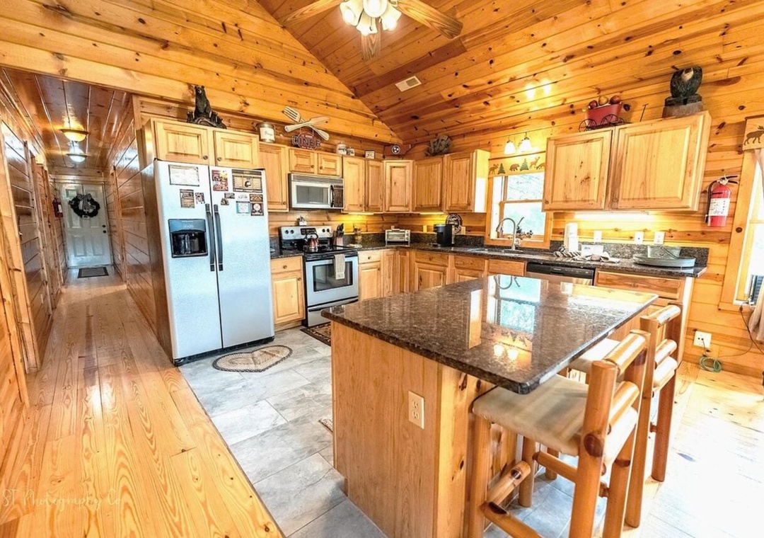Your rustic mountain kitchen features warm pine cabinetry, granite countertops, and a cozy center island perfect for gathering with loved ones over home-cooked meals.