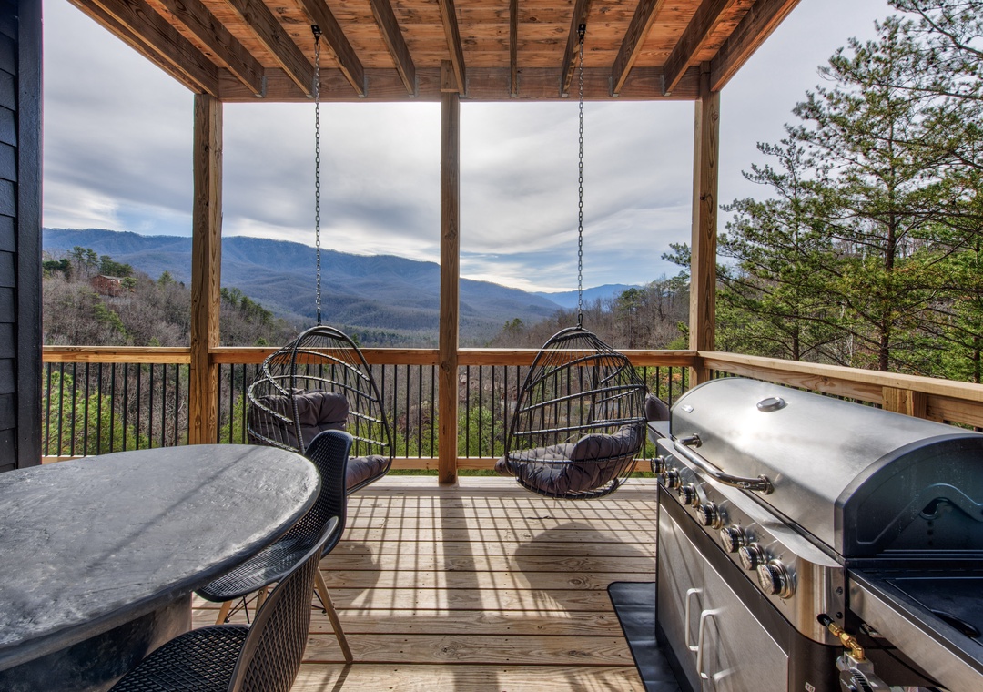 Sway gently in hanging chairs while grilling on your private covered deck, watching endless mountain ridges unfold beneath dramatic skies.