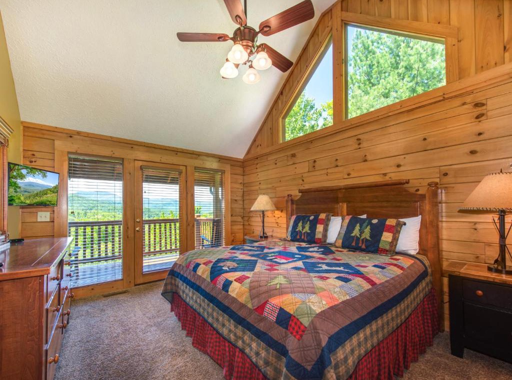Wake up to stunning mountain views from your cozy cabin bedroom, where rustic wood walls meet modern comfort for the perfect retreat.