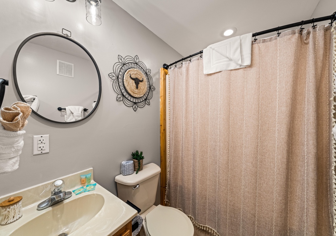 Step into your serene, spa-like bathroom with a rainfall shower, stylish decor, and thoughtful touches including plush towels and all the essentials you need to unwind after a day of adventure.