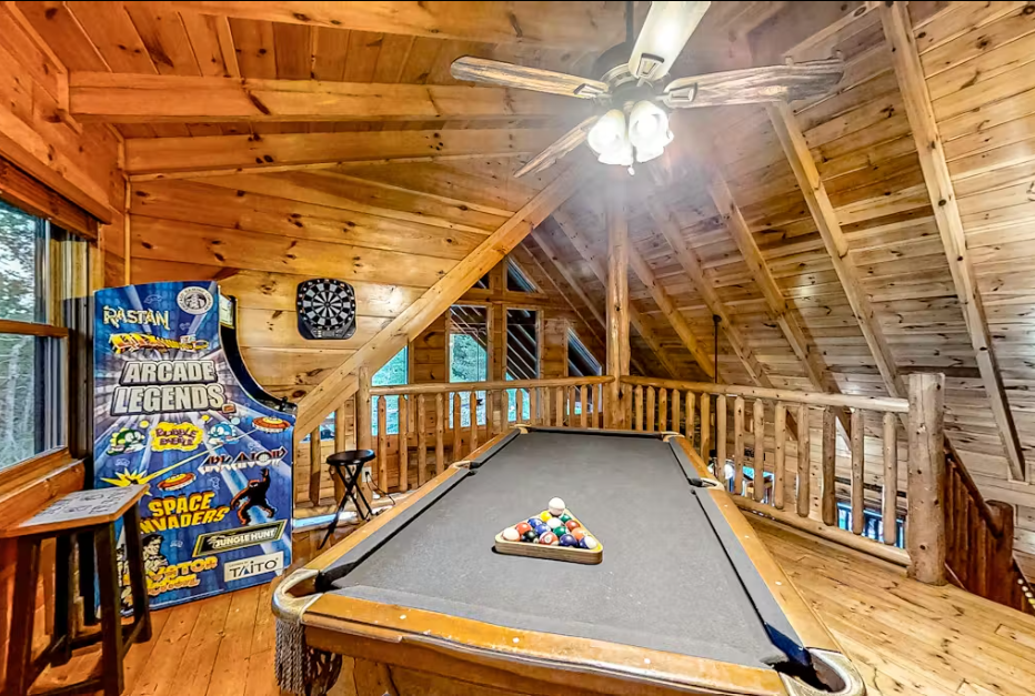 Your private game loft awaits with pool table and vintage arcade for endless entertainment under rustic beams.