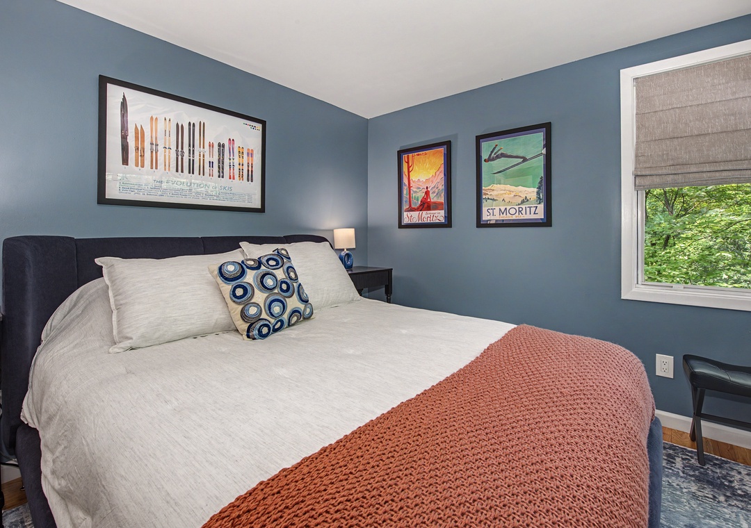 Sink into crisp linens and plush pillows after a day of adventure. The calming blue walls and vintage travel posters create a cozy retreat for restful nights.