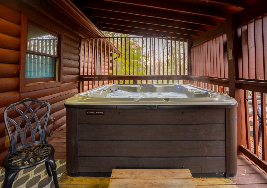 Soak in your private hot tub on this secluded covered deck, surrounded by natural wood and forest views for ultimate relaxation.