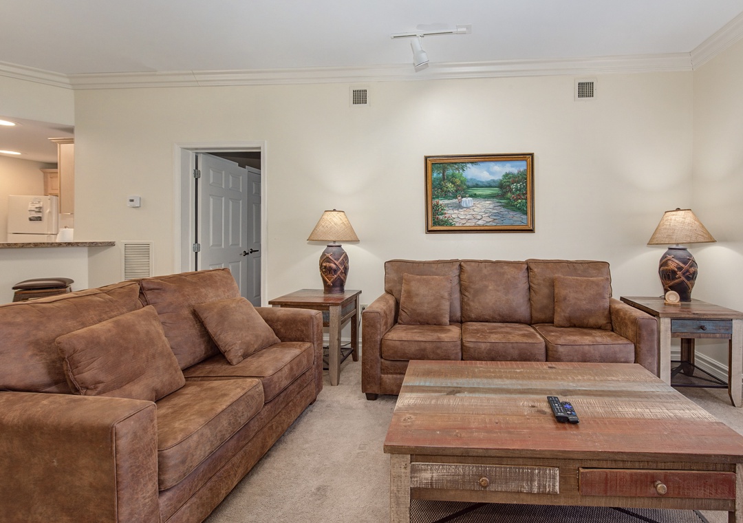 Sink into plush leather sofas in your spacious living room, where warm lighting and thoughtful decor create the perfect retreat.