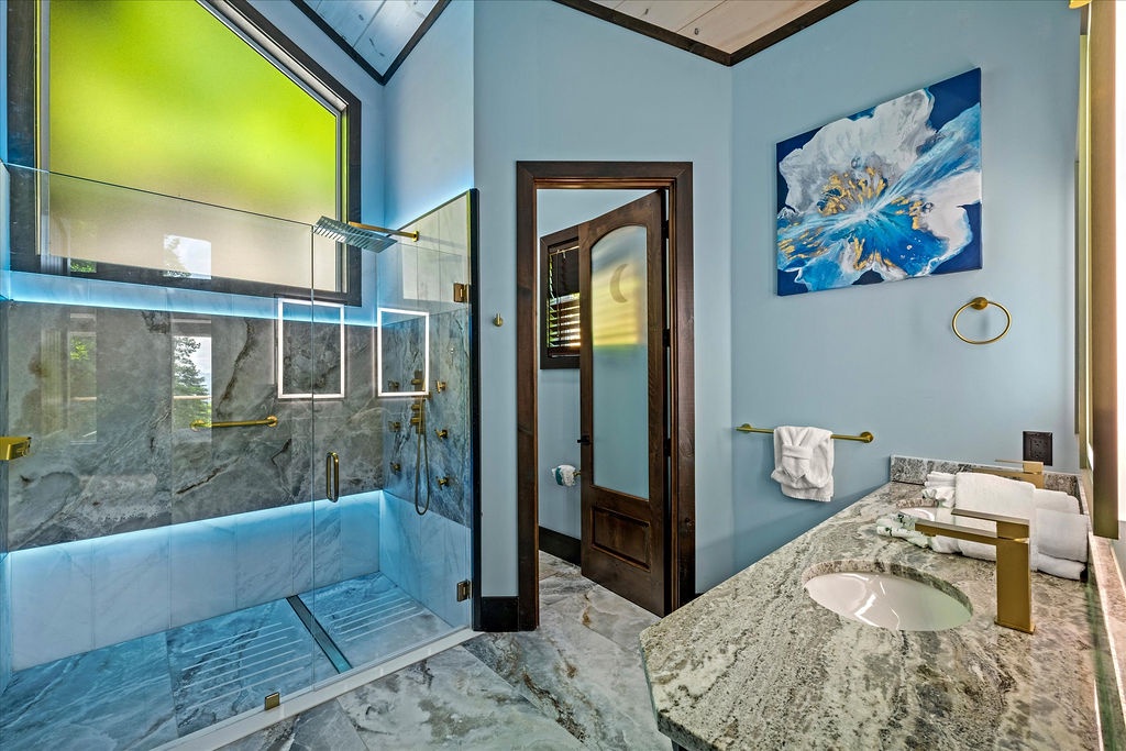 Step into your private spa-like sanctuary, where marble walls and a skylight-topped shower create a bright, airy escape you'll adore returning to each day.