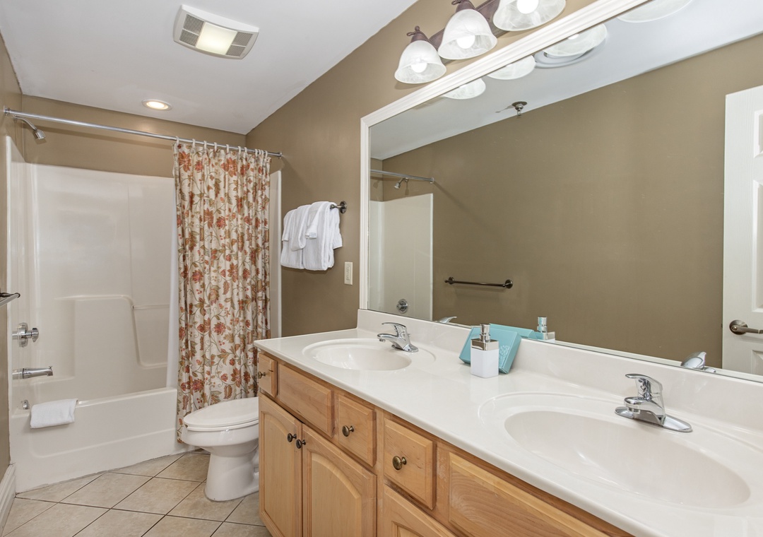 Step into your spacious bathroom featuring dual sinks, perfect for sharing morning routines, plus a relaxing tub-shower combo for unwinding after adventures.