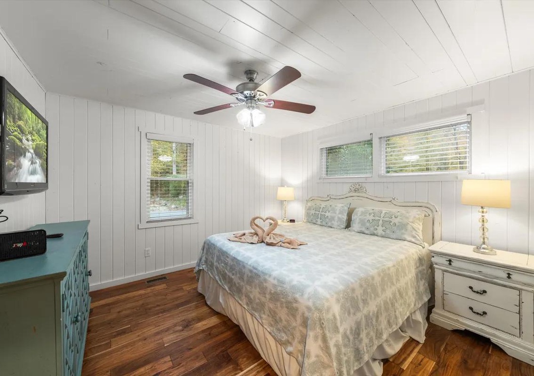 Slip into your cozy retreat with soft linens, charming cottage details, and gentle natural light streaming through the windows. Your bedside lamps and ceiling fan keep you comfortable year-round.