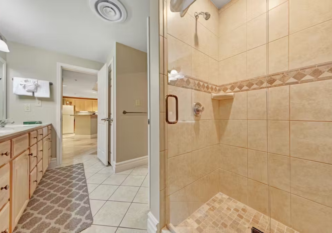 Step into your spacious bathroom featuring a luxurious walk-in shower with elegant tile work and modern glass enclosure for your comfort.