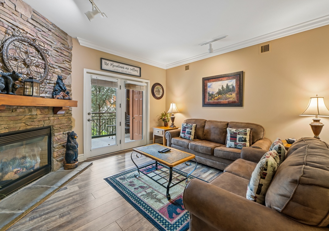 Settle into your cozy living room where warm leather seating and a crackling fireplace create the perfect mountain retreat atmosphere.