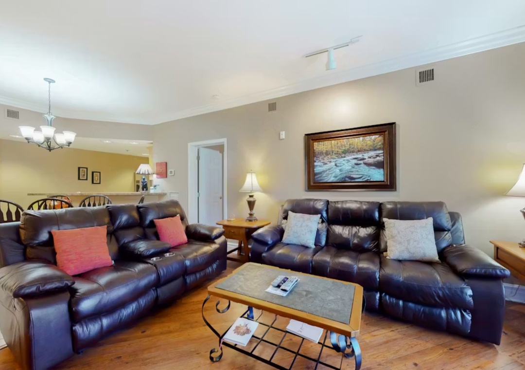 Sink into plush leather recliners in your spacious living room, where warm lighting and thoughtful touches create the perfect spot for relaxation.