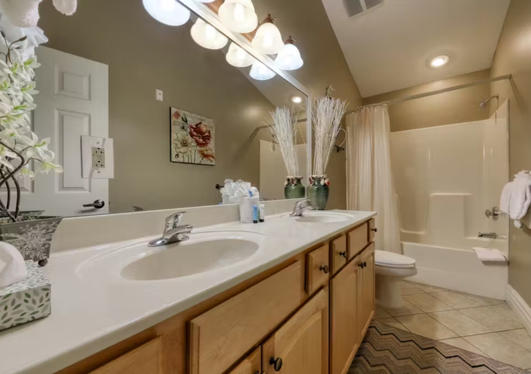 Step into your spa-like bathroom with dual sinks, elegant lighting, and a relaxing tub-shower combo for unwinding after your adventures.