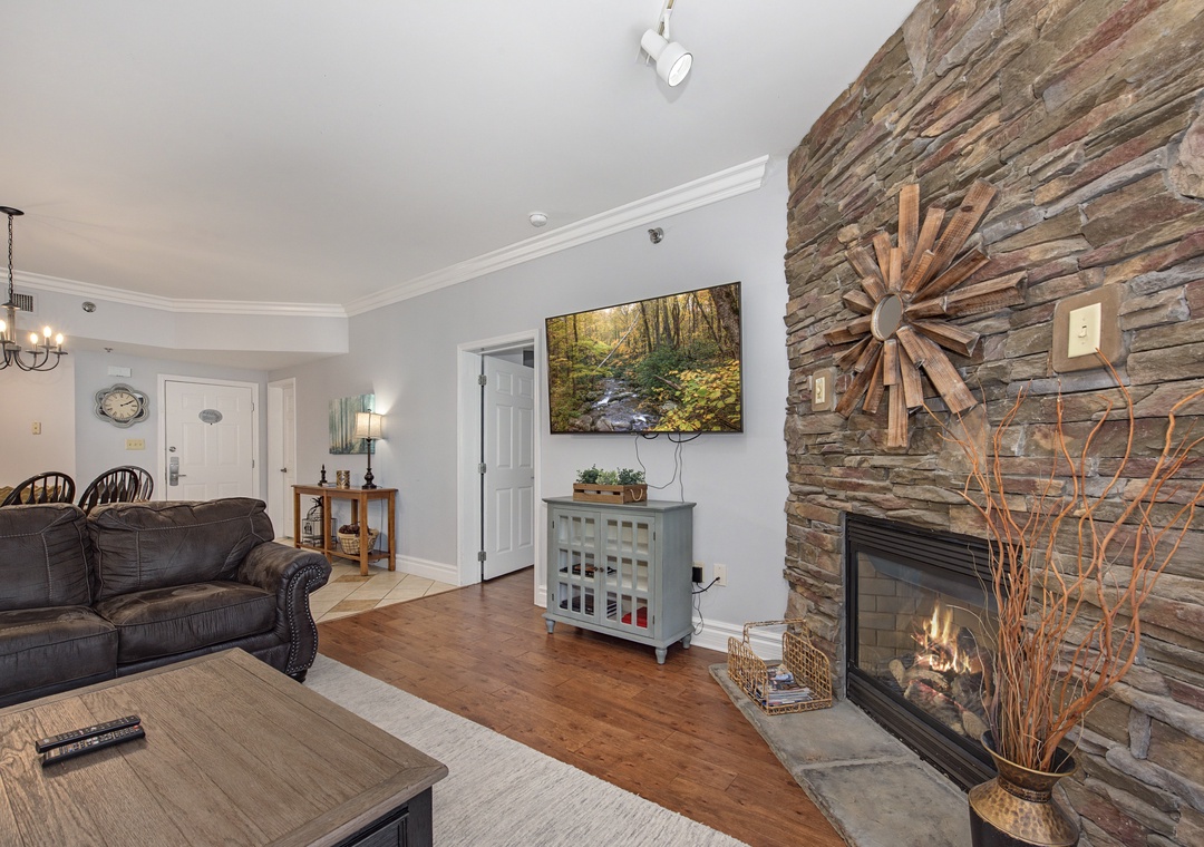 Unwind in your cozy living room with rustic stone fireplace and modern comforts for the perfect mountain getaway.