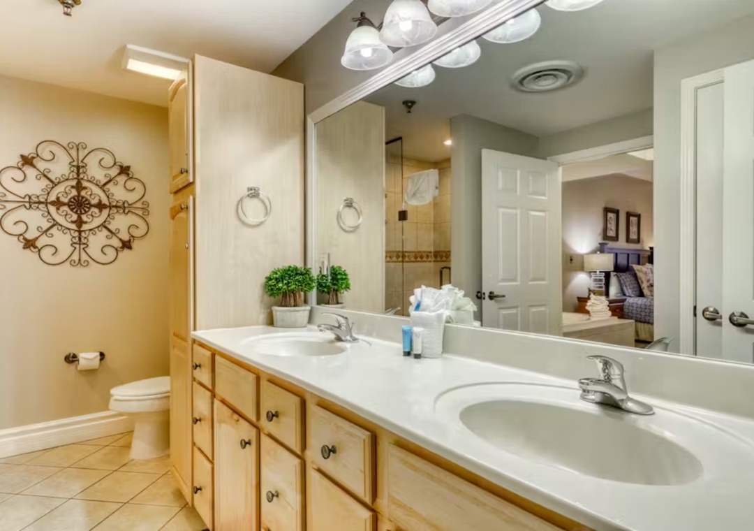 Your spacious bathroom features dual sinks and warm wood cabinetry, creating the perfect space to refresh before your adventures.