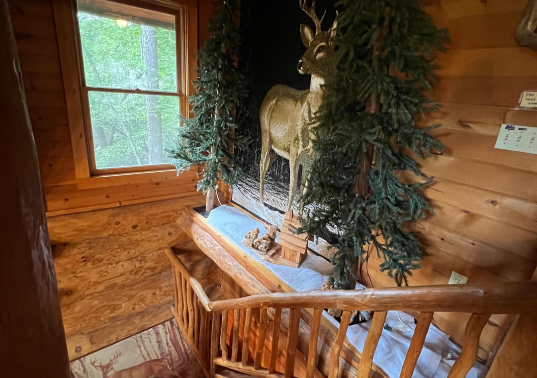 A cozy cabin stairway showcasing rustic charm with warm wood paneling and a striking wildlife display, welcoming you to your mountain retreat.