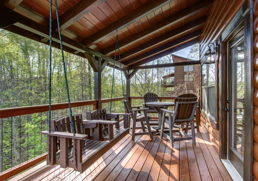 Your private forest retreat awaits with a cozy swing and dining space overlooking lush woodland views.