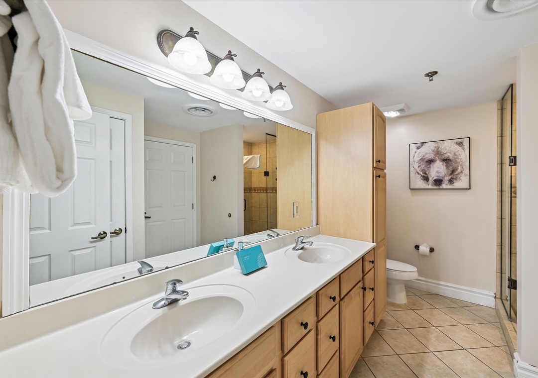 Your spacious bathroom features dual vanities, bright lighting, and a separate shower area for comfortable morning routines.