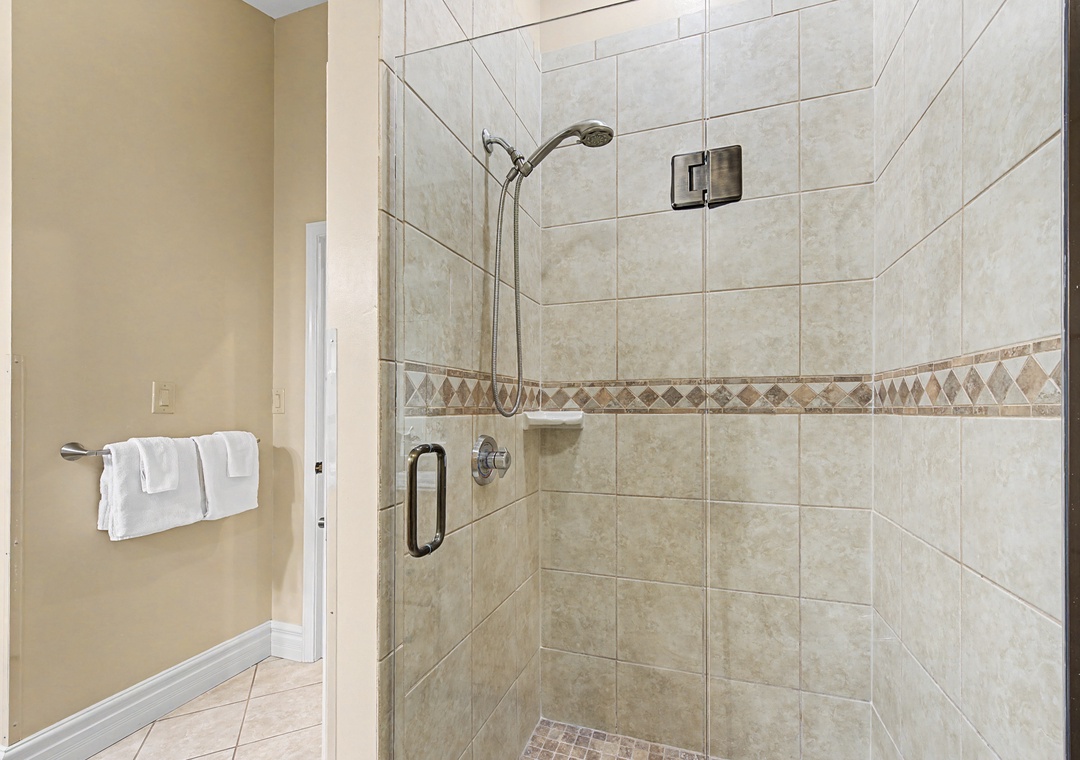 Step into your private spa-like shower with elegant tile work and glass enclosure for a refreshing start to your day.