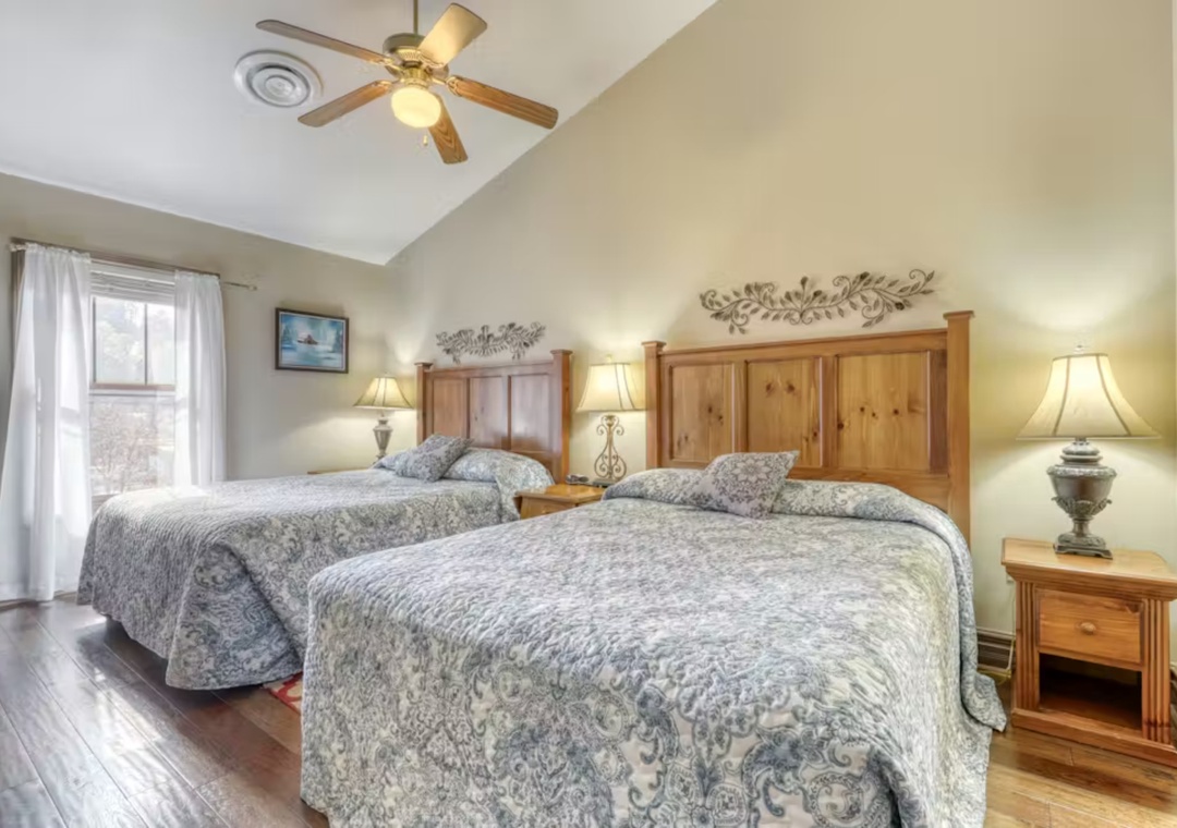 Settle into your cozy twin bedroom with rustic wood furnishings, soft linens, and peaceful natural light streaming through the windows.