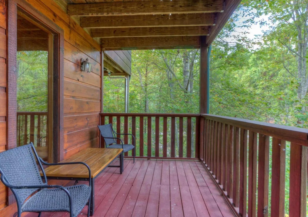 Relax on your private covered balcony, where comfortable seating and lush forest views create the perfect retreat for morning coffee or peaceful evenings surrounded by nature.