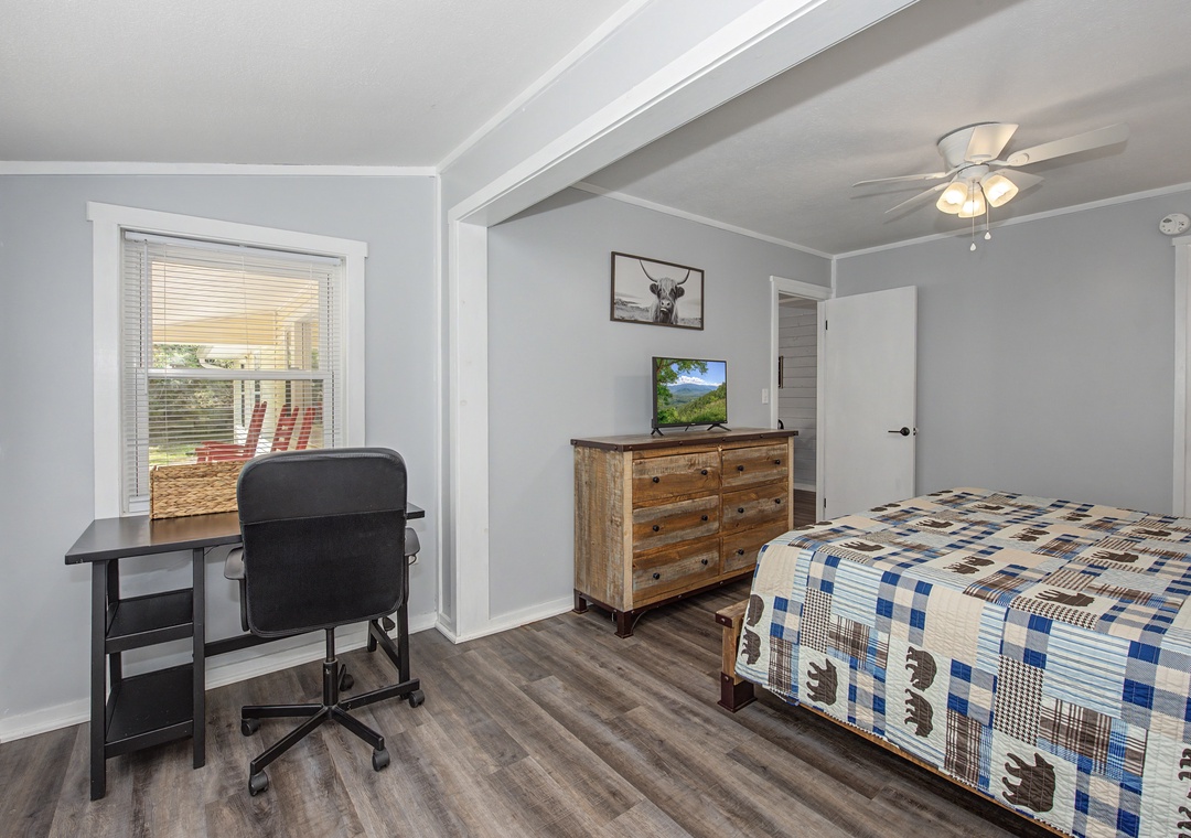 Relax in your bright bedroom with rustic charm, complete with workspace and TV for comfortable stays.