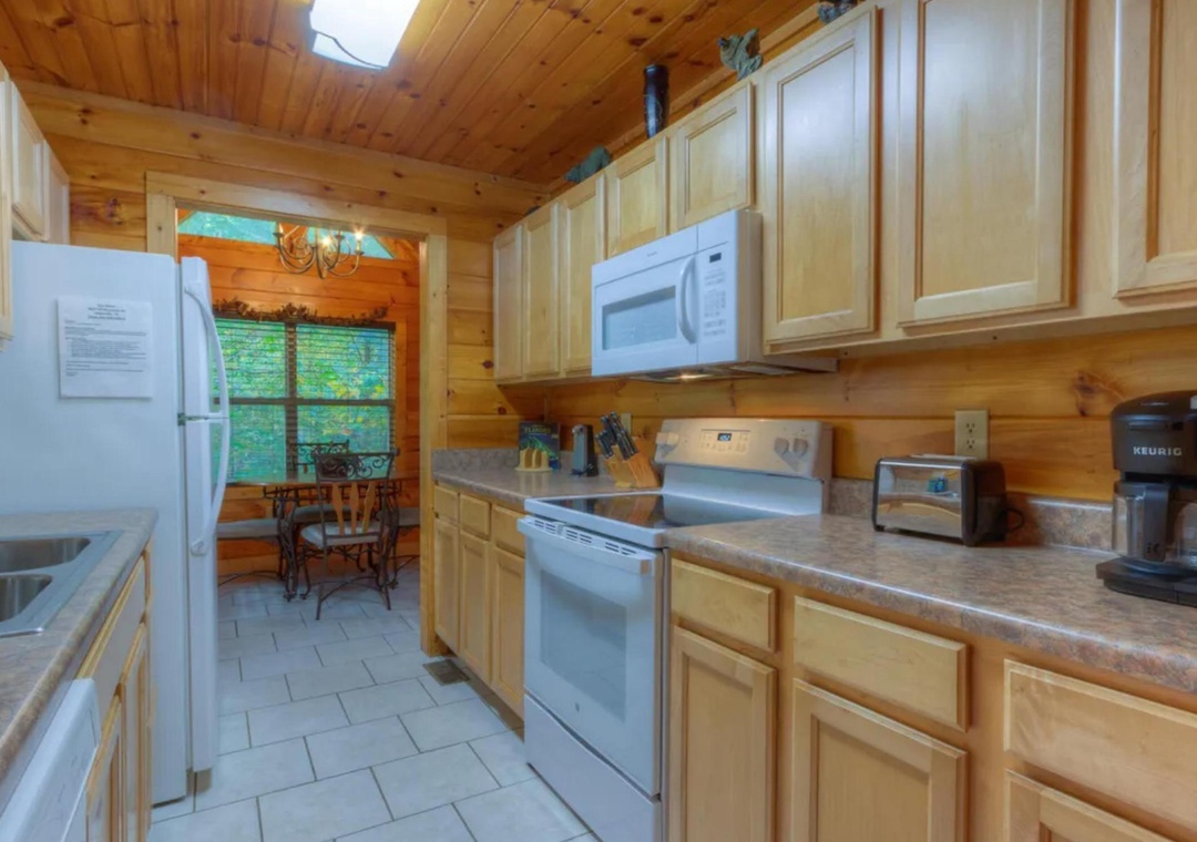 A fully equipped kitchen awaits your culinary adventures, with modern appliances and warm wood finishes throughout. The adjacent dining nook offers cozy meals with views of the surrounding greenery.