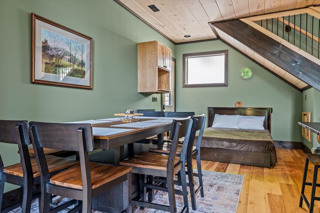 Step into your cozy loft retreat with soaring ceilings and warm wood accents. Gather around the dining table after a day of exploring, then unwind in your comfortable bed beneath the charming exposed beam.