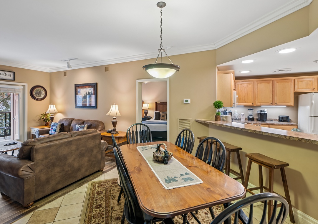 Your spacious open-concept living area invites relaxation with plush leather seating, warm lighting, and a fully-equipped kitchen ready for memorable meals together.