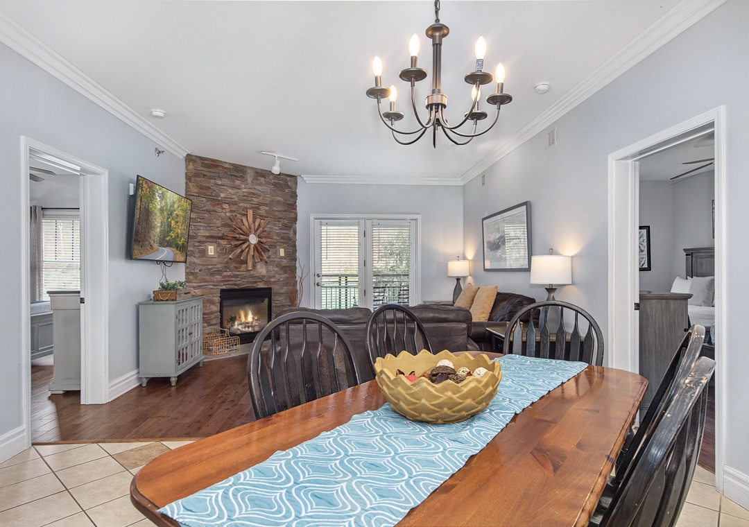 Gather around your elegant dining table while the fireplace creates a cozy ambiance in this open living space.