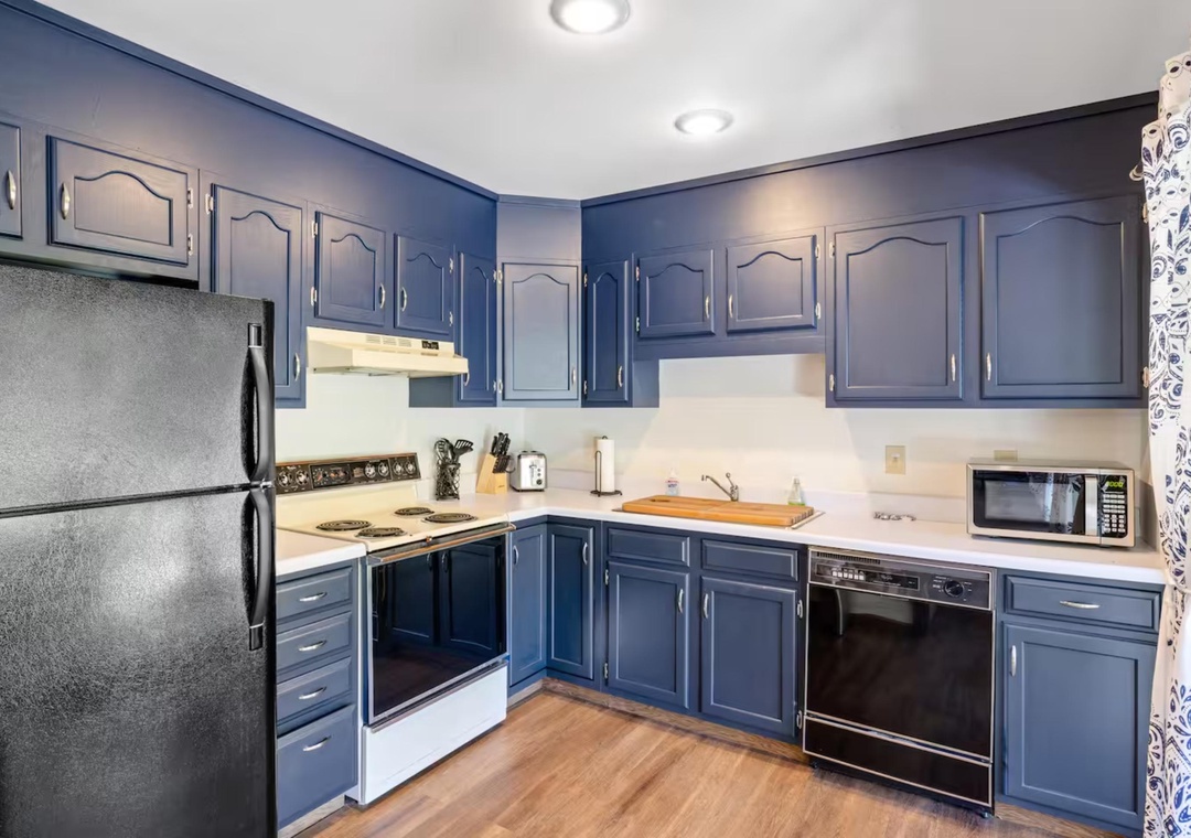 Your fully equipped kitchen features beautiful blue cabinetry, stainless appliances, and everything you need to create memorable meals during your stay.