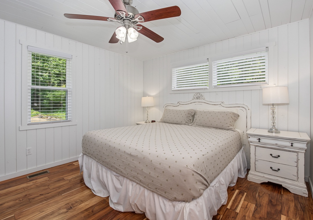 Sink into the plush bedding and let the ceiling fan's gentle breeze lull you to sleep. Natural light filters through the windows, warming the rich hardwood floors and inviting you to start your morning refreshed.