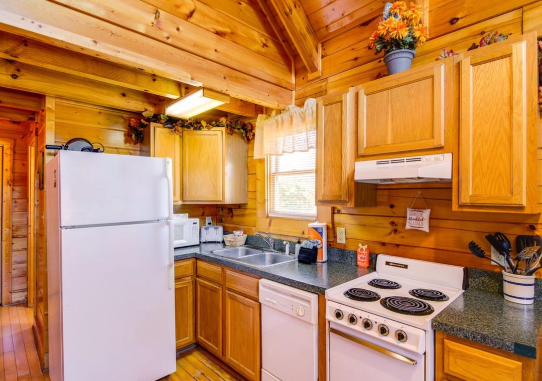 You'll love preparing meals in this charming rustic kitchen with warm wood beams, full appliances, and cozy cabin character.