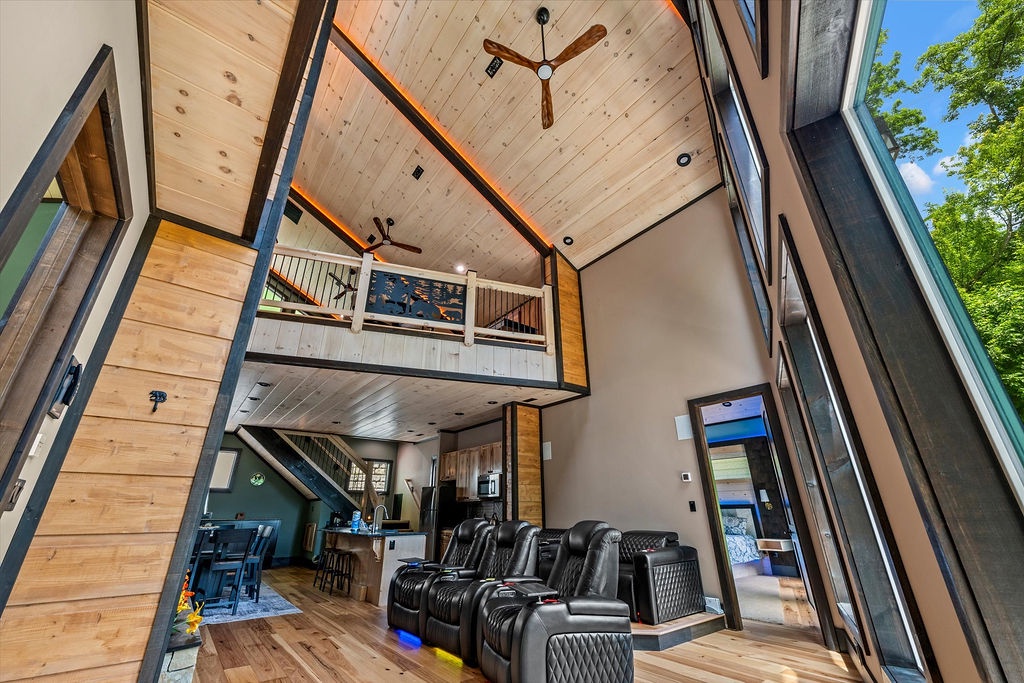Soaring ceilings and floor-to-ceiling windows flood this open-concept space with natural light, creating an airy retreat where you can unwind in plush recliners or gather upstairs in the loft.