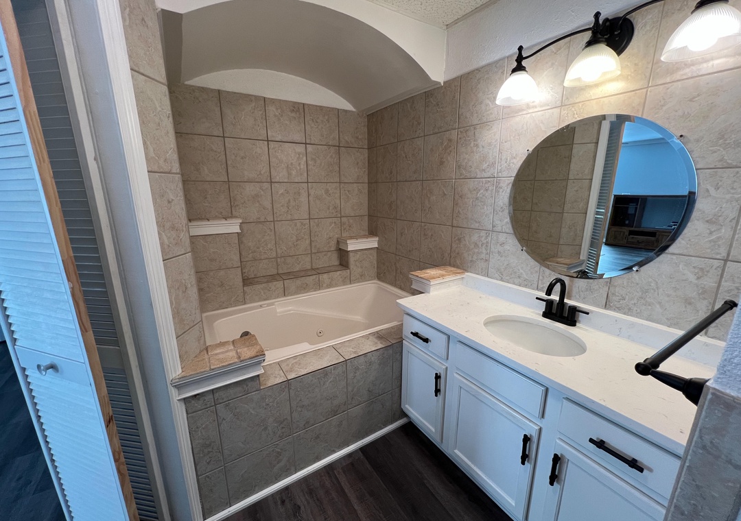 Luxurious bathroom featuring your own jetted tub with elegant stone surround and designer vanity.
