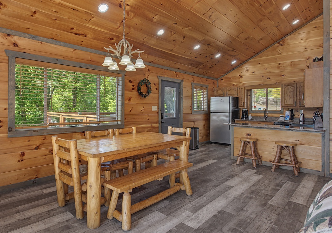 Gather around the handcrafted log table in your cozy cabin, where natural wood and forest views create the perfect spot for meals and making memories together.