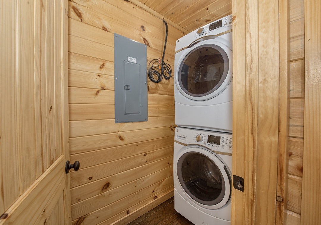 Your vacation laundry just got easy—stacked washer and dryer tucked into warm wood paneling, ready whenever you need them.