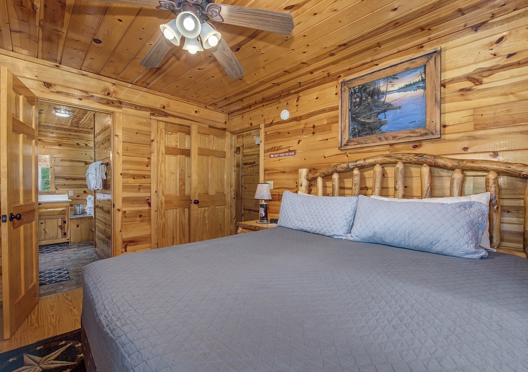 Sink into the plush bedding of your cozy cabin retreat, where warm wood walls and rustic log accents create an inviting mountain escape just steps from your private ensuite.