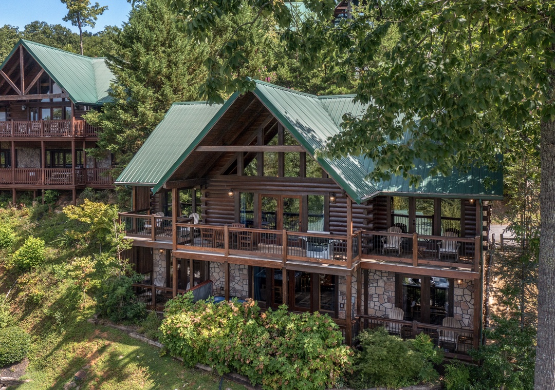 Stunning log cabin retreat nestled in lush forest with multiple decks and expansive windows for enjoying nature's tranquility.