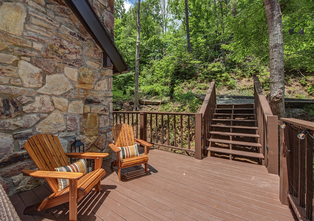 Settle into your private deck surrounded by lush forest, where two Adirondack chairs invite you to unwind with morning coffee or evening conversation amidst the peaceful mountain setting.