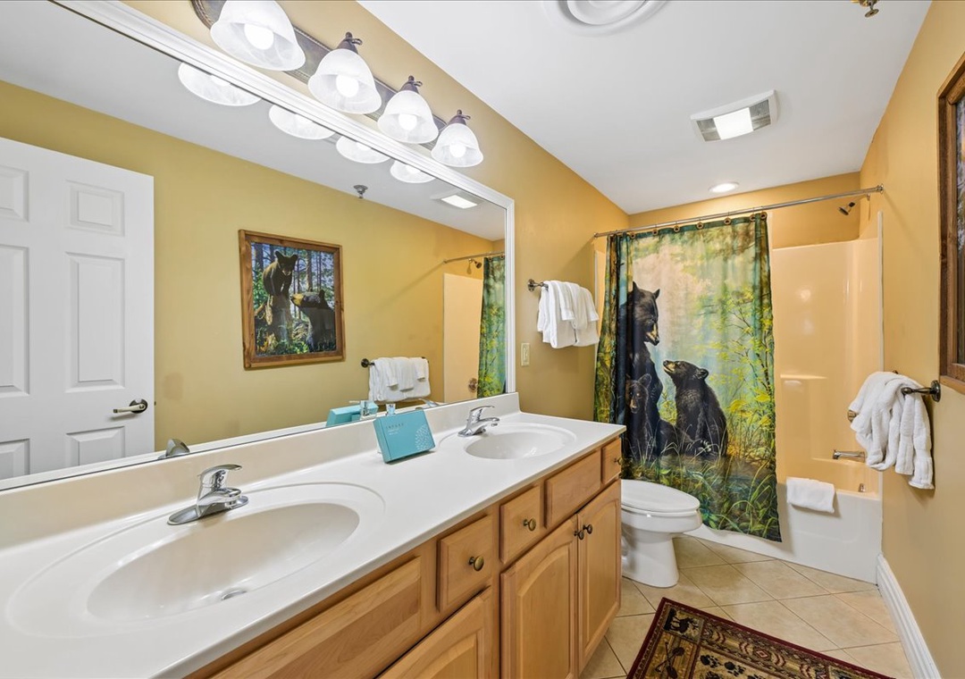 Your spacious bathroom features dual sinks, wildlife artwork, and thoughtful touches like fresh towels for your comfort.