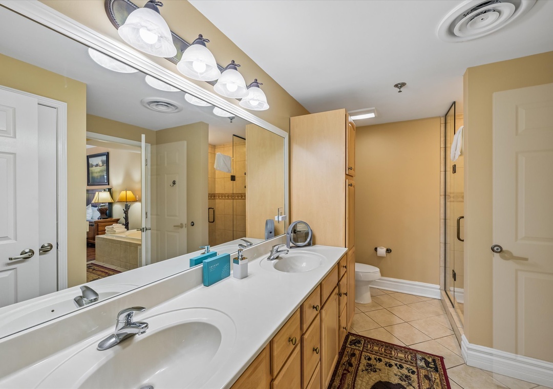 Your spacious master bathroom features dual sinks, ample counter space, and a glass-enclosed shower for your morning routine.