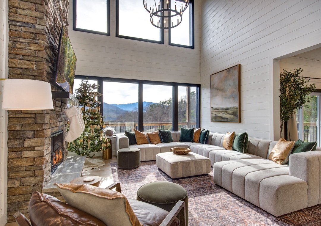 Sink into plush sectional seating by the crackling fireplace while mountain vistas frame your perfect retreat through floor-to-ceiling windows.
