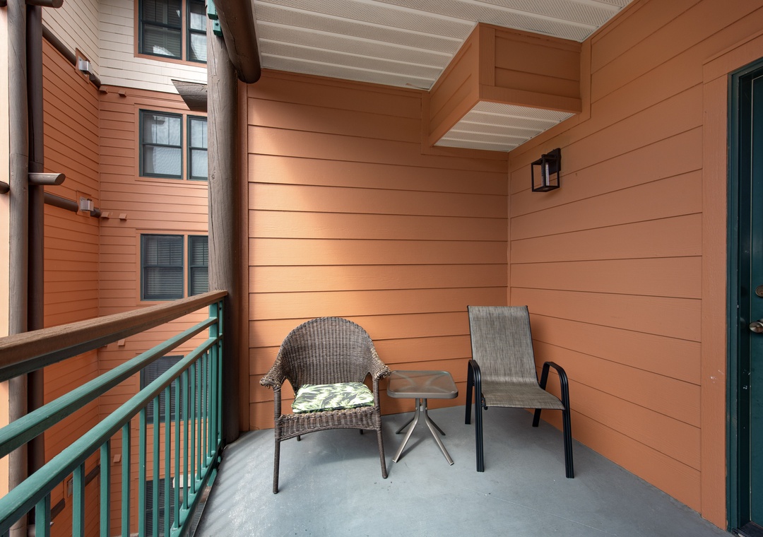 Step onto your private balcony where wicker chairs and a side table create the perfect morning coffee spot.