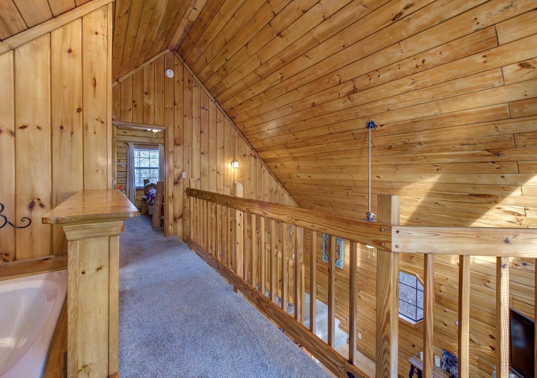 Step into your cozy loft hallway, where rich wood surrounds you in warmth and rustic charm throughout.
