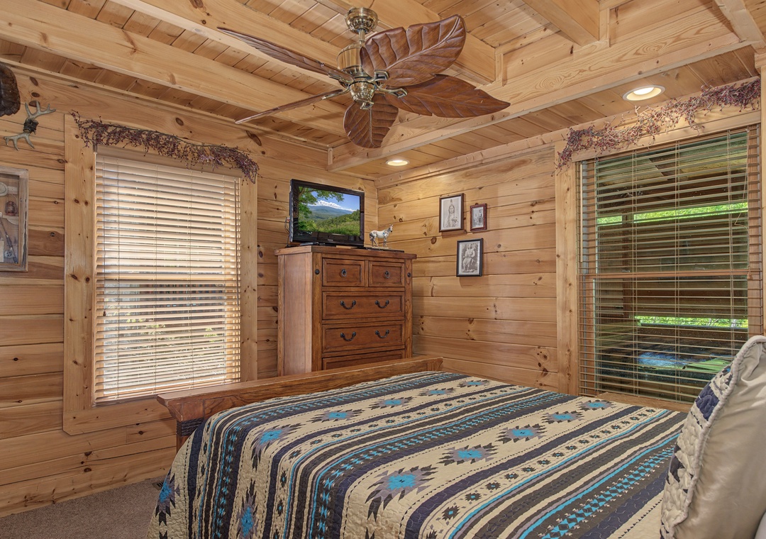 Cozy log cabin bedroom with rustic charm, comfortable bedding, and peaceful forest views from your windows.